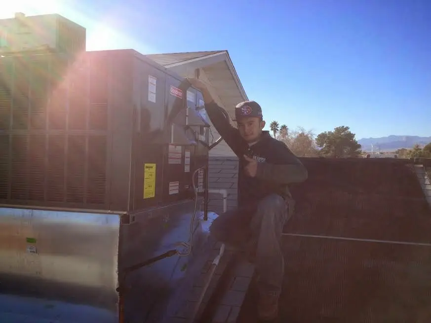 HVAC technician performing Air Duct Cleaning on a rooftop unit in Ferndale